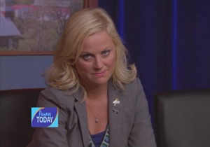 Blonde woman in a blazer, giving an exasperated look to the camera